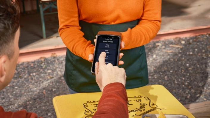 Restoran masasında akıllı telefon kullanan müşteri ve dijital servis deneyimi