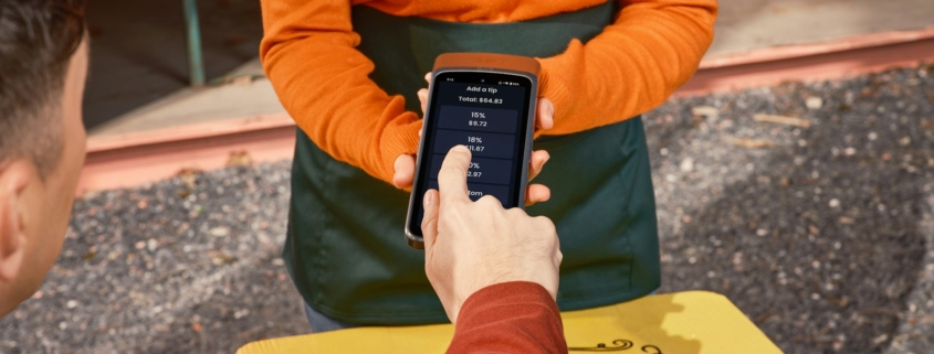 Restoran masasında akıllı telefon kullanan müşteri ve dijital servis deneyimi